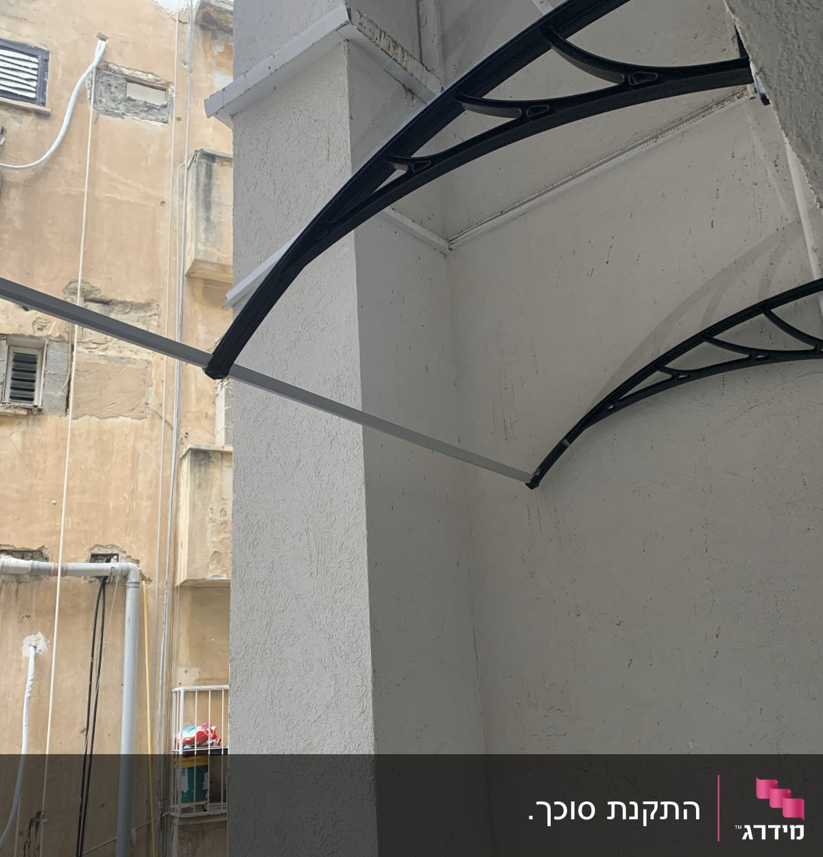 סוכך עם תומכות מתכת על קיר חיצוני